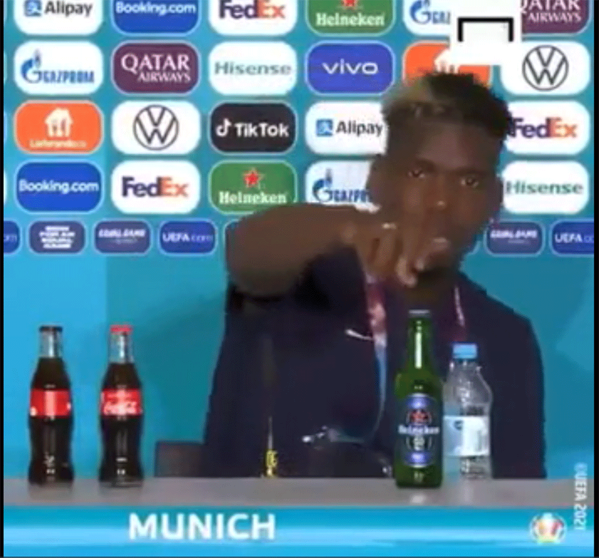 Paul Pogba follows Cristiano Ronaldo as he removes bottle of Heineken from press conference