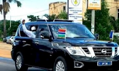Photojournalist Captures President Barrow Waving At Small Crowd From Window Of His Car As He Returns To The Country From Niger