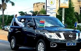 Photojournalist Captures President Barrow Waving At Small Crowd From Window Of His Car As He Returns To The Country From Niger